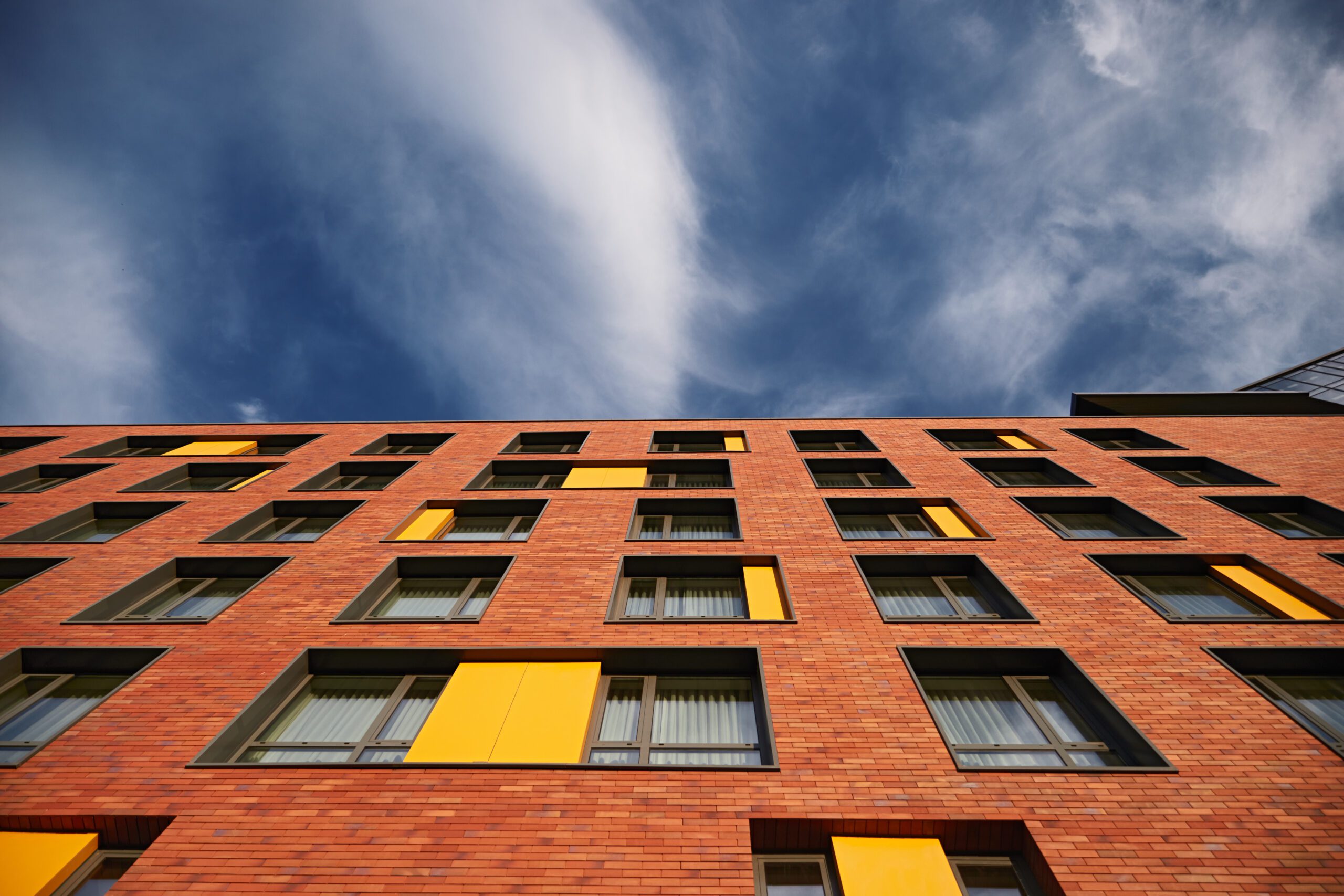 Modern brick building under cloudy sky affordable student accommodation